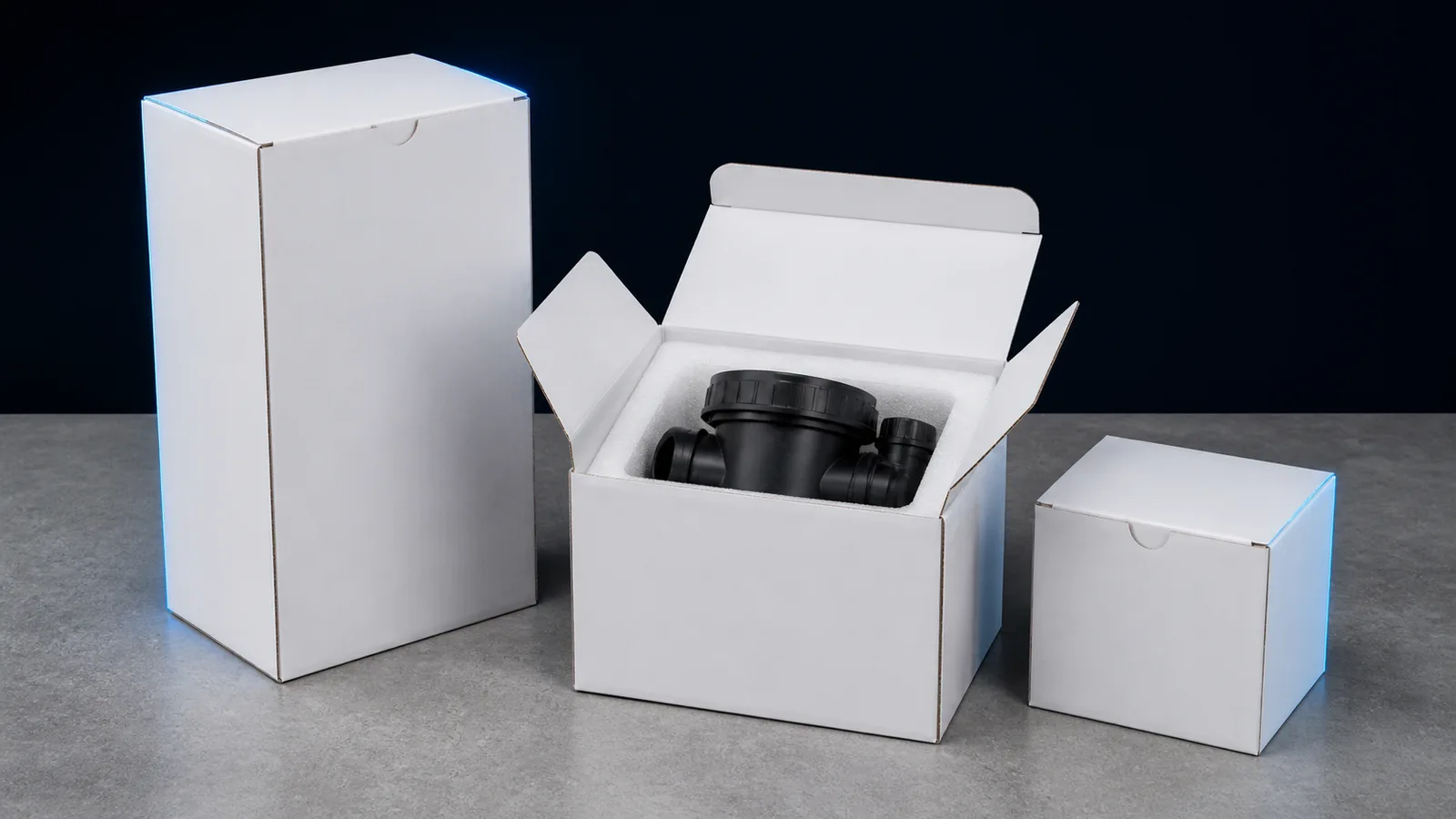 Three plain unprinted cartons, one open with a moulded part inside foam